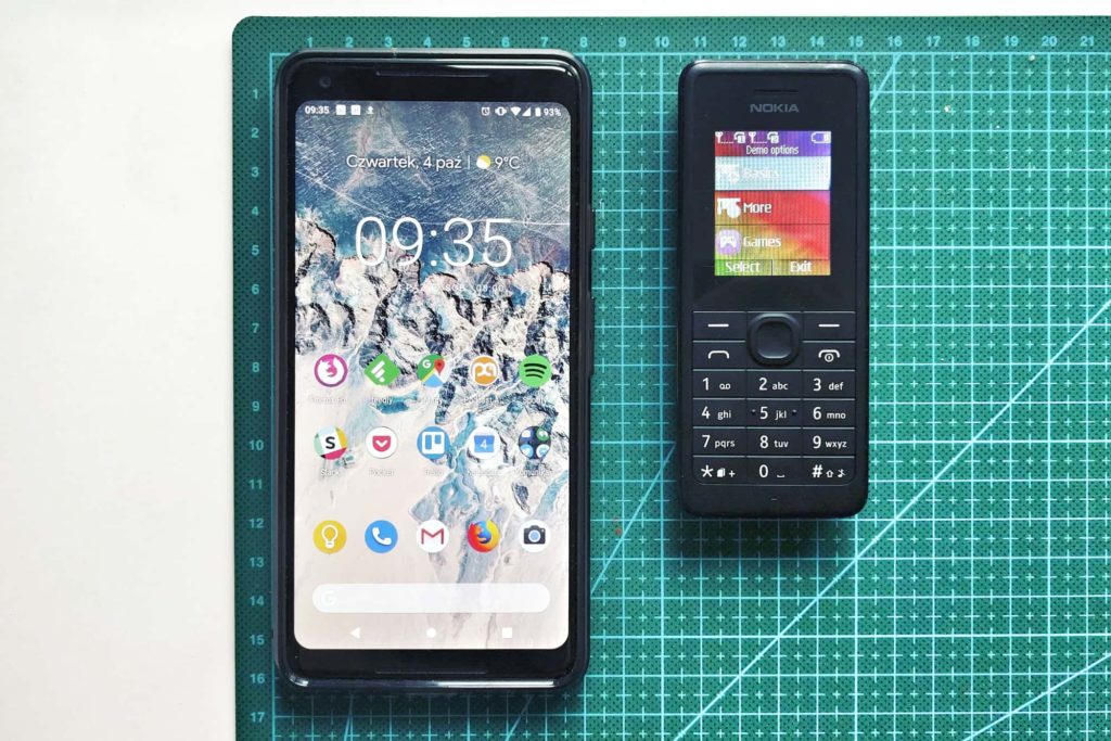 Smartphone Google Pixel 2 obok starego modelu Nokii z klawiaturą numeryczną.